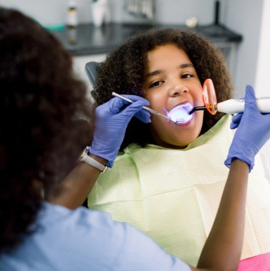 Child receiving dental bonding treatment