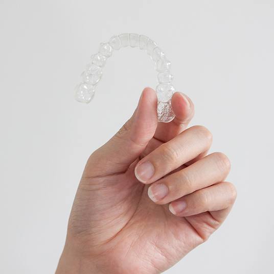 Closeup of patient holding clear aligner