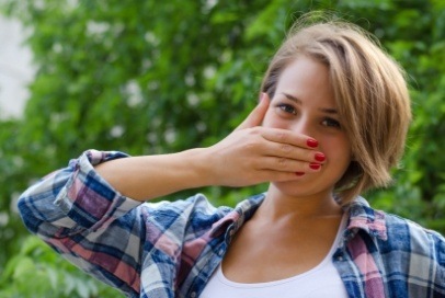 Teen girl with chipped tooth covering her mouth