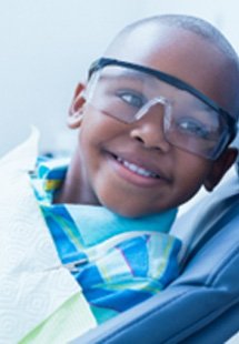 Smiling child wearing goggles before dental checkup