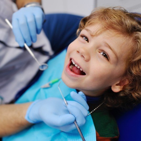 Child smiling during dental checkup and teeth cleaning
