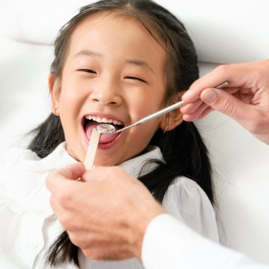 Child smiling during hospital dentistry treatment